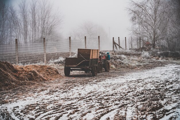 Besneeuwd veld met een wagen vastgemaakt aan een motorfiets met vier wielen