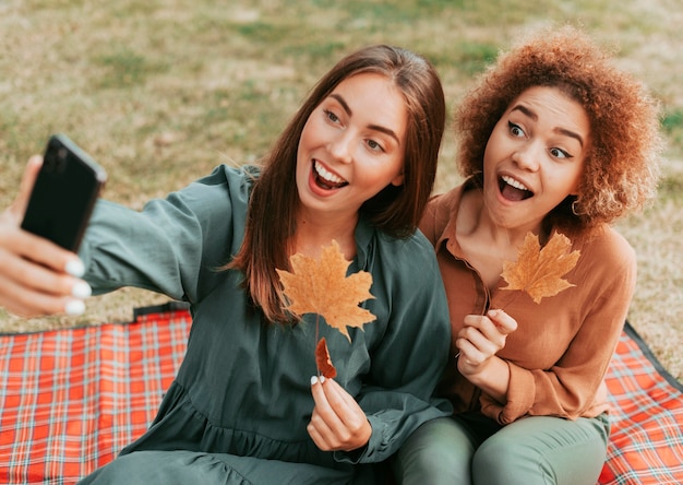 Gratis foto beste vrienden die samen een selfie maken in de herfst