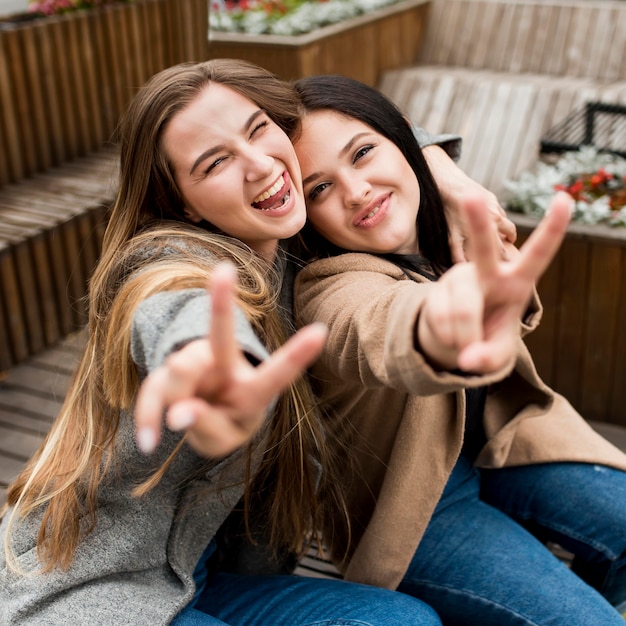 Gratis foto beste vrienden poseren tijdens het tonen van het vredesteken