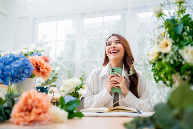 Bestelling nemen bloemist werkt vanuit homeyoung aziatische bloemist maakt lijst van klant bestelling om bloemboeket vaasbezorging te regelen Bloemontwerp winkel geluk glimlachende jonge dame die bloemenvaas maakt