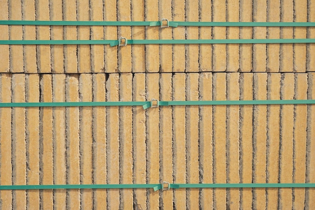 Bestrating gele wegtegels verpakt met groene tape op pallets in opslag Goederen in voorraad bouw en reparatie levering en verkoop van bouwmaterialen