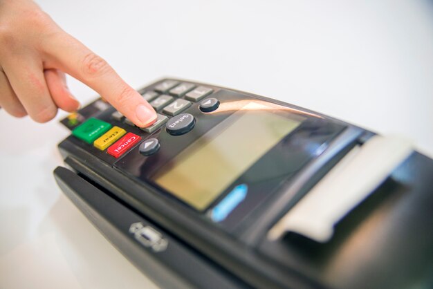 Betalingskaart in een bank terminal. Het concept van elektronische betaling. Hand pin code op pin pad van kaart machine of pos terminal goede foto