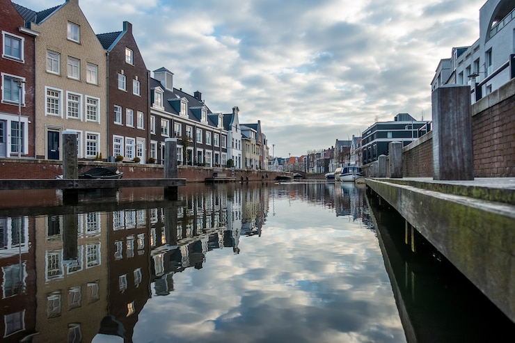 Gratis Foto betoverend uitzicht op de weerspiegeling van de gebouwen in de rivier op een bewolkte dag