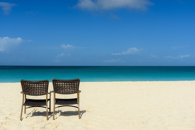 betoverend uitzicht op het strand en de zee, met twee stoelen aan de kust