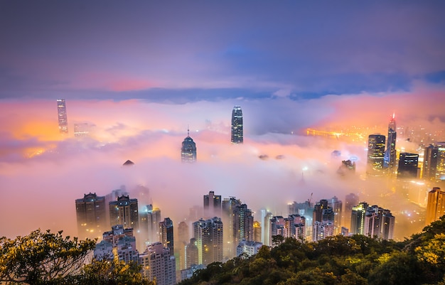 Betoverende opname van de wolkenkrabbers van een stad die 's nachts in mist is gehuld