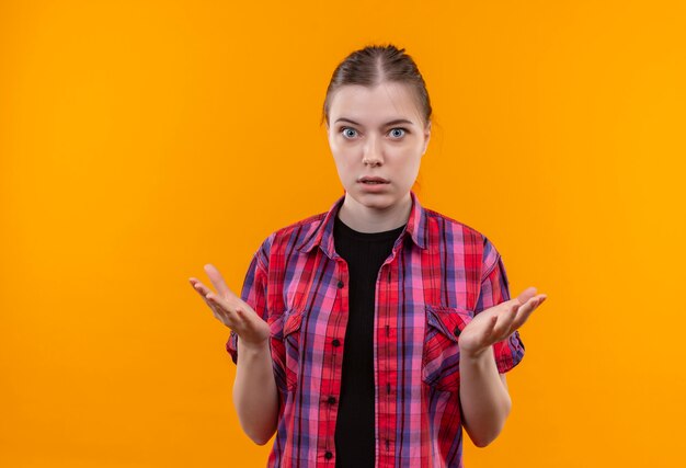 betrokken jonge mooie vrouw, gekleed in rood shirt met hand op geïsoleerde gele muur