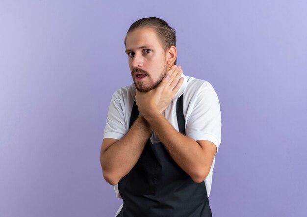 Beu jonge knappe kapper die uniform draagt ?? zelfmoordgebaar probeert zichzelf te stikken geïsoleerd op paars met kopie ruimte