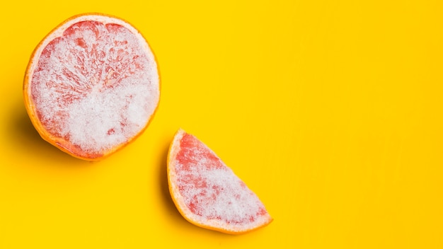 Gratis foto bevroren grapefruit op gele achtergrond