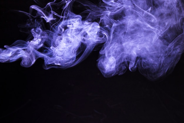 Gratis foto beweging van zachte paarse rook op zwarte achtergrond