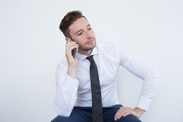 Bezette mannelijke manager die op de telefoon communiceert
