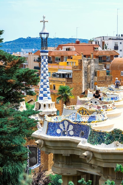 Bezoekers van Parc Guell op een uitkijkpunt met een ongewoon stadsbeeld in bouwstijl van Barcelona