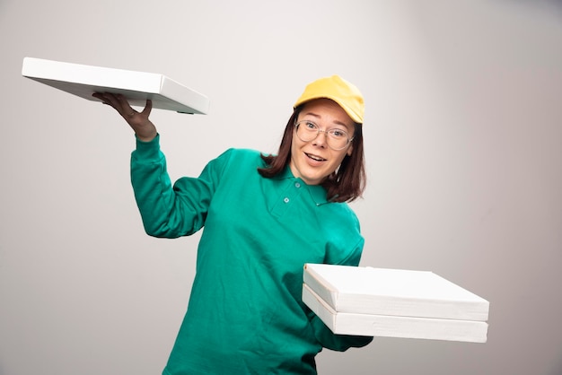 Gratis foto bezorger die karton van pizza op een wit draagt. hoge kwaliteit foto