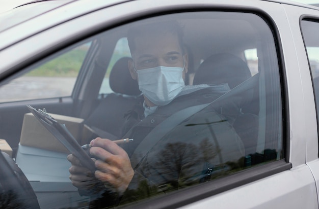 Gratis foto bezorgmannetje met masker en pakjes