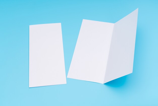 Bifold wit sjabloon papier op blauwe achtergrond.