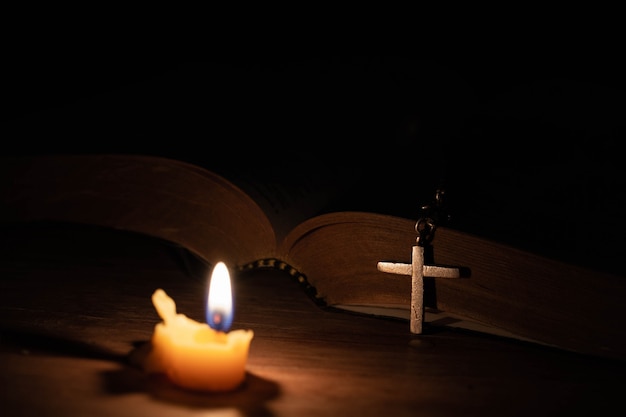 Bijbel, houten kruis en kaarsen