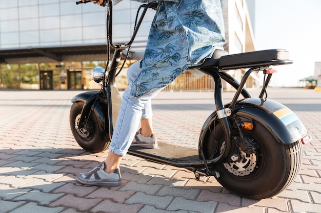 Bijgesneden afbeelding van een vrouw zittend op een motorfiets