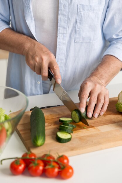 Bijgesneden afbeelding van volwassen aantrekkelijke man koken salade.
