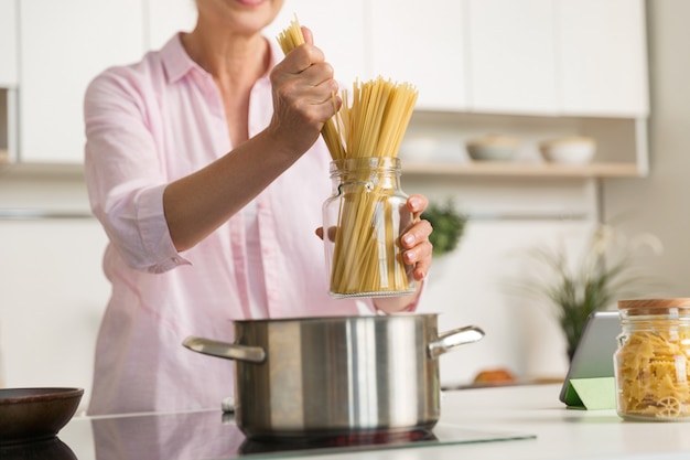 Bijgesneden afbeelding van volwassen vrouw koken.