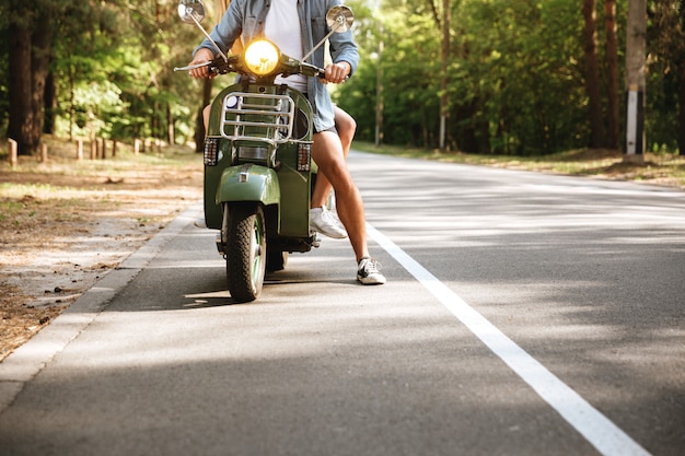 Bijgesneden foto van jonge aantrekkelijke verliefde paar op scooter