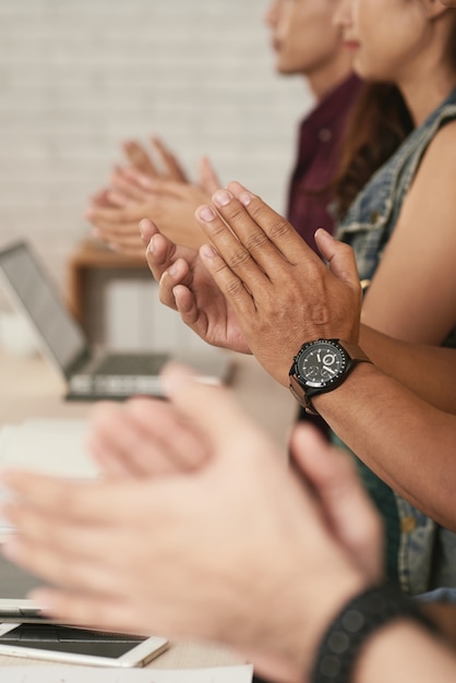 Bijgesneden handen van een groep mensen applaudisseren om de spreker te motiveren