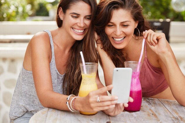 Bijgesneden opname van tevreden gelukkige jonge vrouwen die winkelen in webwinkels, blij om een nieuwe aankoop te kiezen
