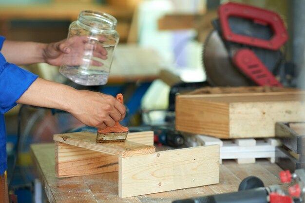 Bijgesneden schrijnwerker polijsten hout op de werkbank