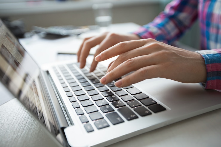 Gratis Foto bijgesneden weergave van handen die op laptop typen