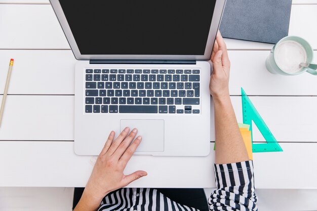 Bijsnijonderneemster die laptop met behulp van