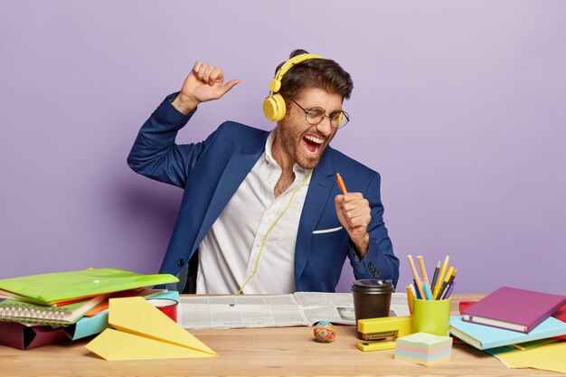 Binnen schot van blij grappige zakenman zittend aan het bureau