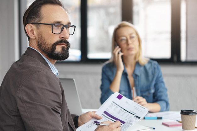 Binnen schot van blonde vrouw met zakelijk gesprek met collega