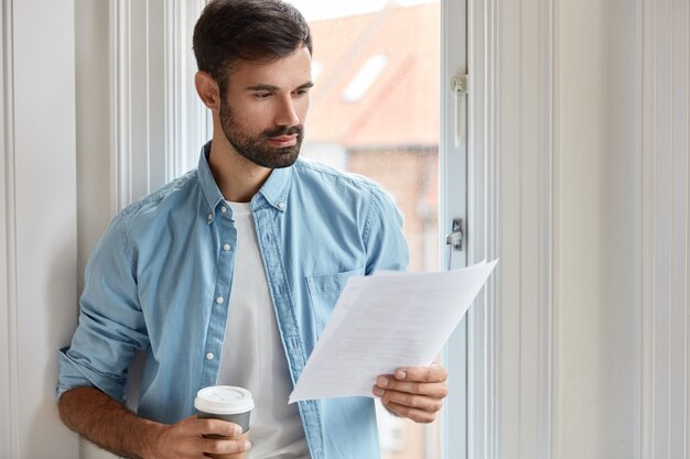 Binnen schot van ernstige bebaarde freelancer thuis werken