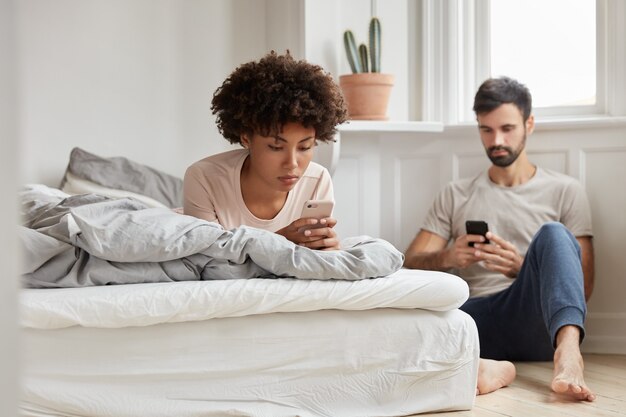 Binnen schot van mooie jonge vrouw die zich voordeed thuis in comfortabel bed