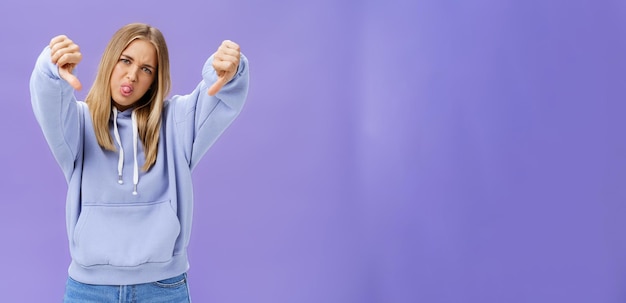 Binnenfoto van humeurige ontevreden en onbetrokken coole moderne vrouw met blond haar en gebroken huid