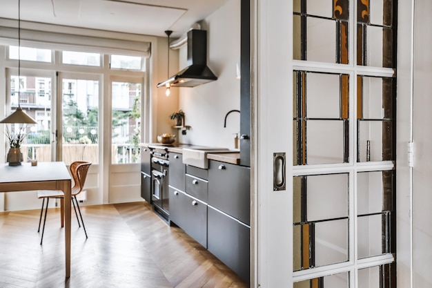 Gratis foto binnenopname van een moderne keuken met decoraties en meubels naast een ingang