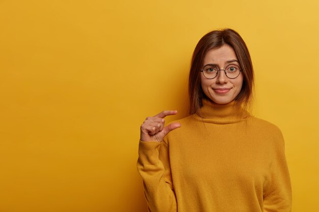 Binnenopname van ontevreden schattige vrouw maakt klein gebaar, vormt iets heel kleins