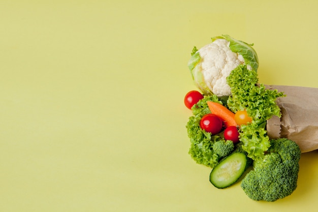 Biologische groenten broccoli komkommers paprika appels in bruine papieren kraft boodschappentas. gezonde voeding dieetvezel vegan
