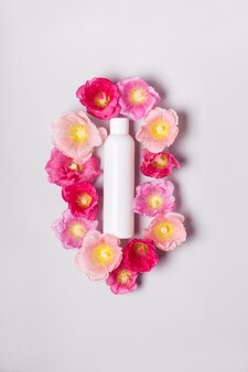 Biologische natuurlijke cosmetica concept. shampoo fles en bloemen kaasjeskruid.