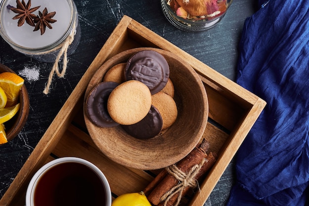 Biscuitkoekjes met chocolade en een kopje thee.