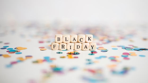 Gratis foto black friday-inscriptie op kleine witte kubussen met confettien