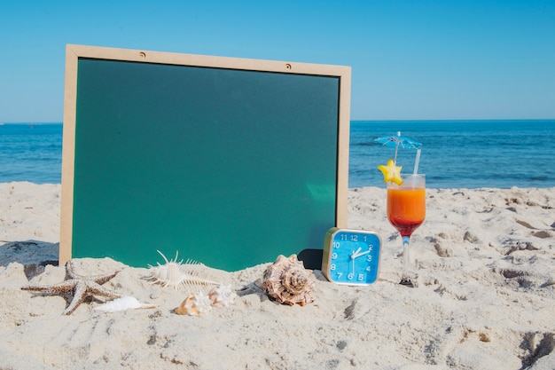 Blackboard en cocktail op het strand