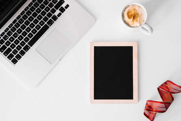 Blackboard in de buurt van laptop en koffie