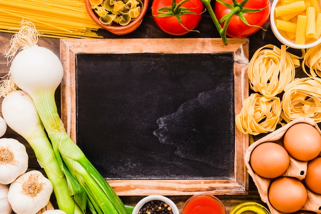 Gratis foto blackboard te midden van pasta-ingrediënten