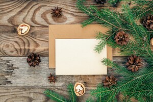Blanco papieren envelop op een houten ondergrond met kerstboomtakken