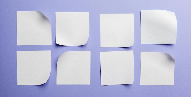 Blanco papieren label of sticker met kopieerruimte plat lag op violette bureaubladachtergrond