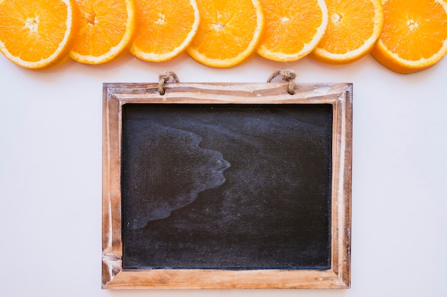 Gratis foto blanco schoolbord met een rij oranje plakjes