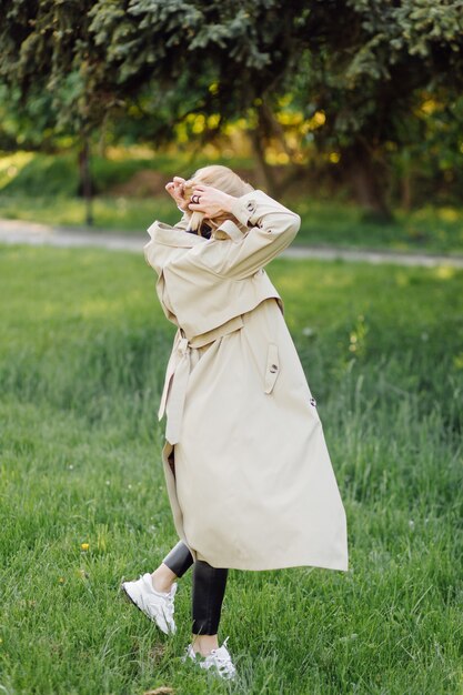 Blanke blonde vrouw wearind geul glimlach gelukkig op zonnige lentedag buiten wandelen in het park