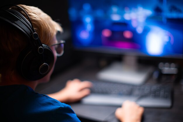 Blanke jonge tienerjongen speelt games op de computer en streamt de games live. neemt deel aan het esports-toernooi