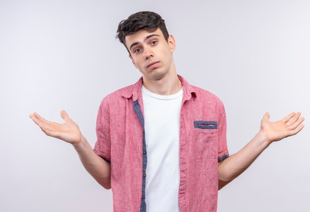 Blanke jongeman met roze shirt spreidt handen op geïsoleerde witte muur