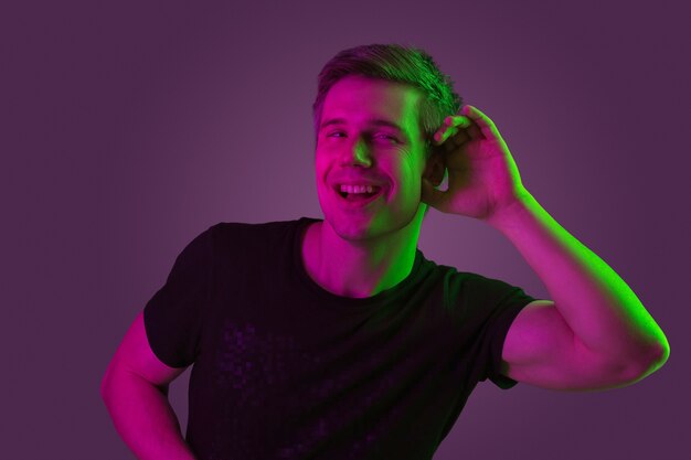 Blanke man portret geïsoleerd op paarse studio in neonlicht