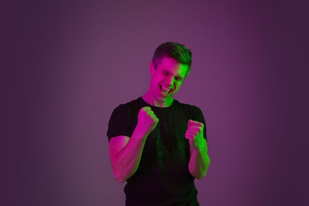 Blanke man portret op paarse studio in neonlicht.